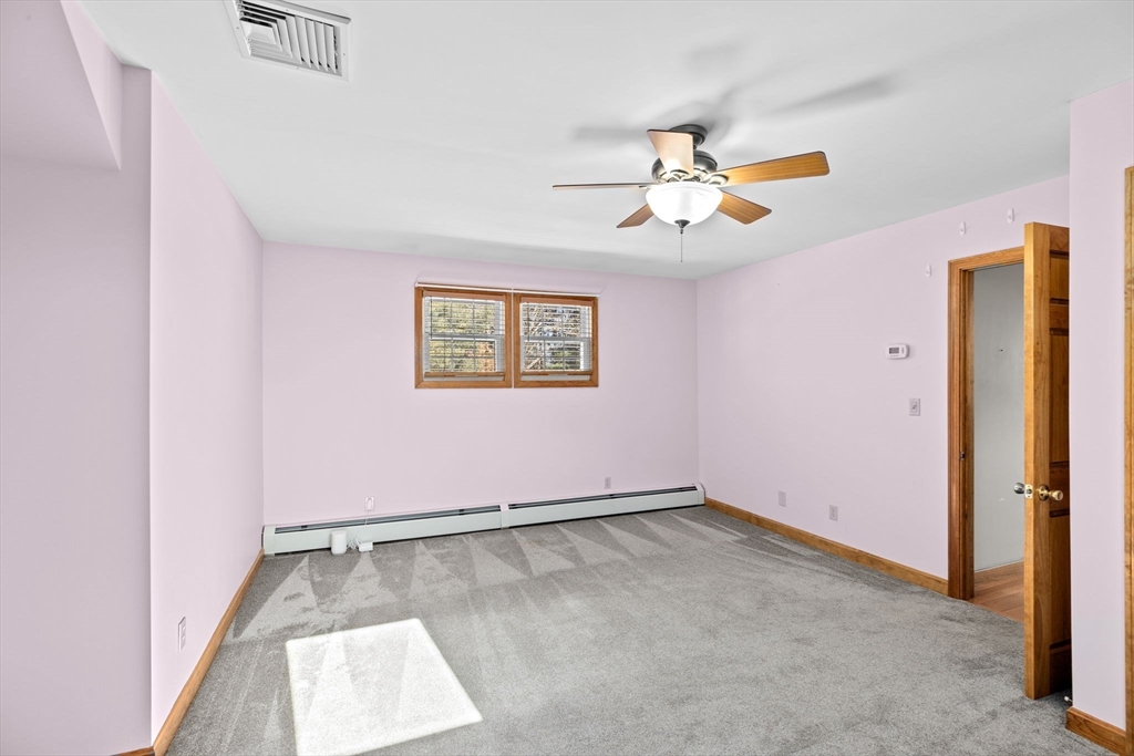 4 Highland Ridge Road Assonet, MA 02702 - Photo 26 of 42 an empty room with a chandelier fan and windows