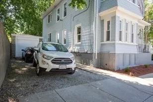 a car parked in front of white house