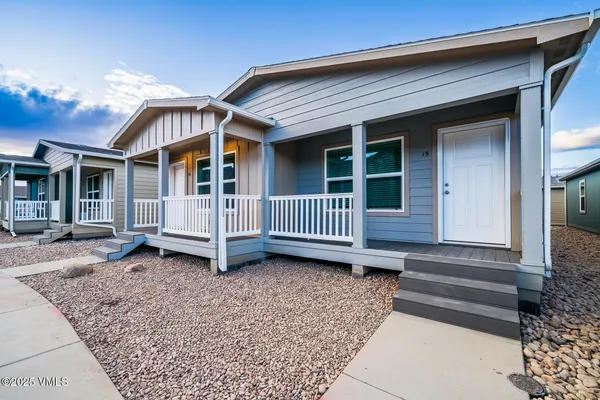 a view of a house with a yard and wooden fence