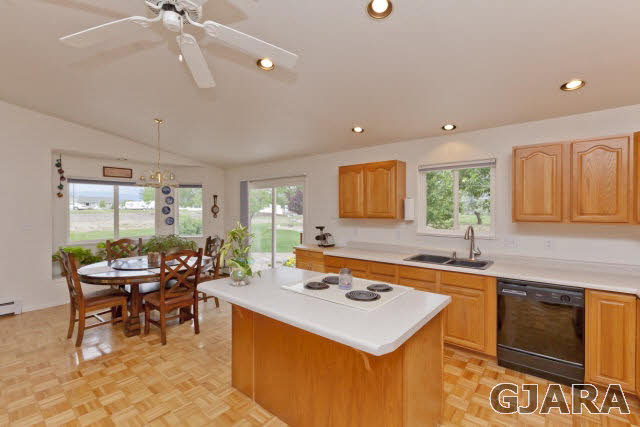 2391 H Road Grand Junction, CO 81505 - Photo 9 of 33 a kitchen with a stove a sink a dining table and chairs