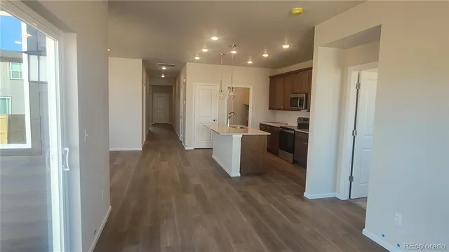 a view of a kitchen with wooden floor and a sink