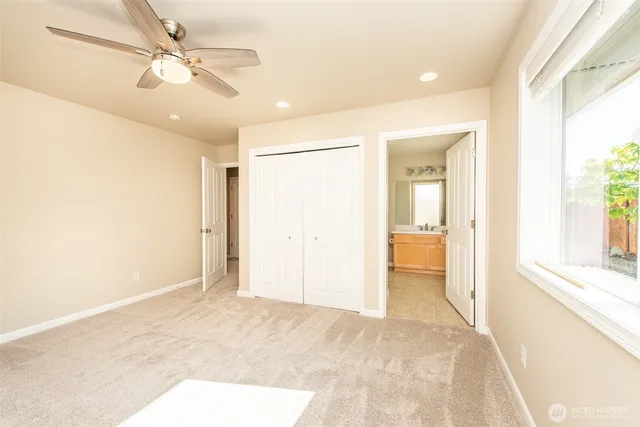 a bathroom with a sink mirror toilet and next to a window