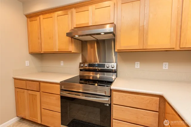 a kitchen with wooden cabinets and a stove top oven