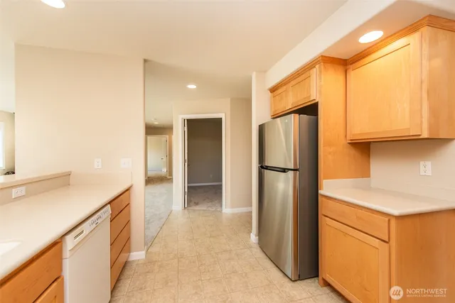 a kitchen with stainless steel appliances granite countertop a refrigerator and a sink