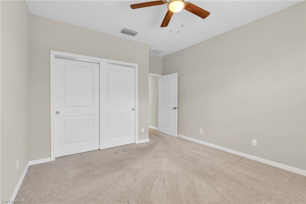 9385 Pocida Court, Unit 101 Naples, FL 34119 - Photo 17 of 26 an empty room with chandelier fan