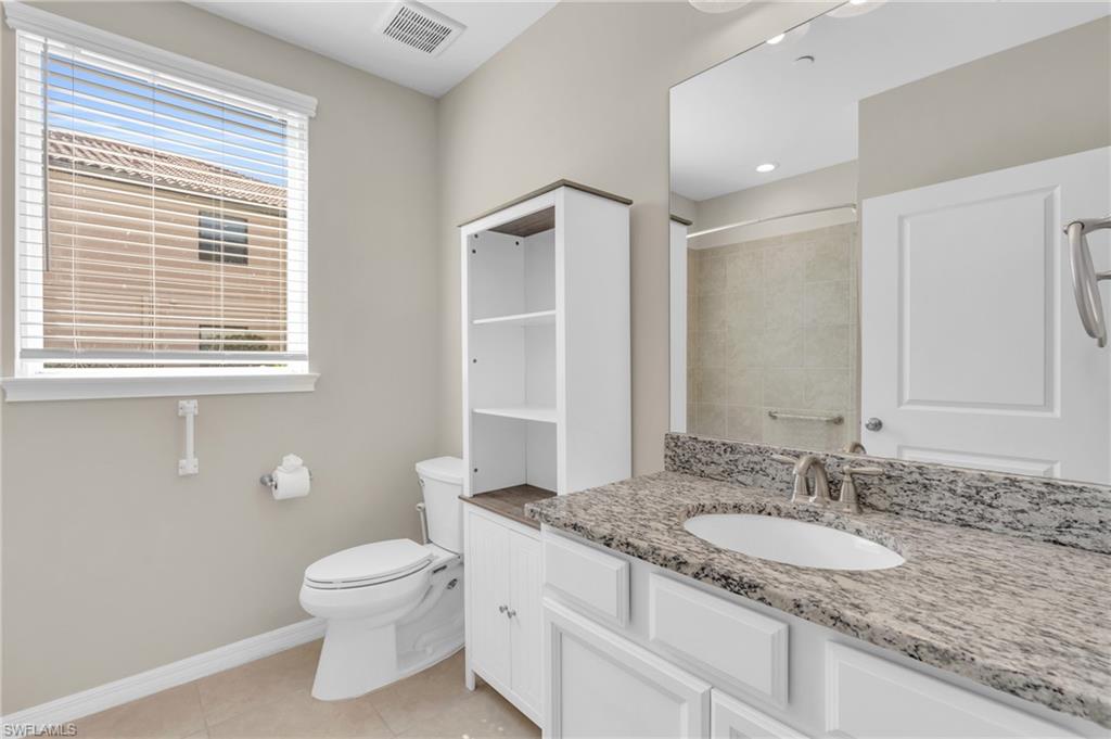 9385 Pocida Court, Unit 101 Naples, FL 34119 - Photo 19 of 26 a bathroom with a granite countertop sink toilet and shower