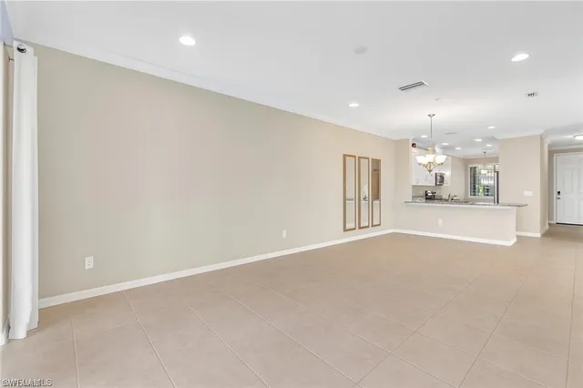 an empty room with a kitchen and windows