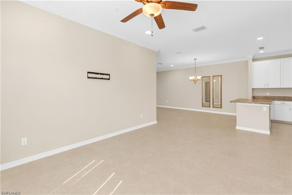 9385 Pocida Court, Unit 101 Naples, FL 34119 - Photo 7 of 26 a view of an empty room with a ceiling fan