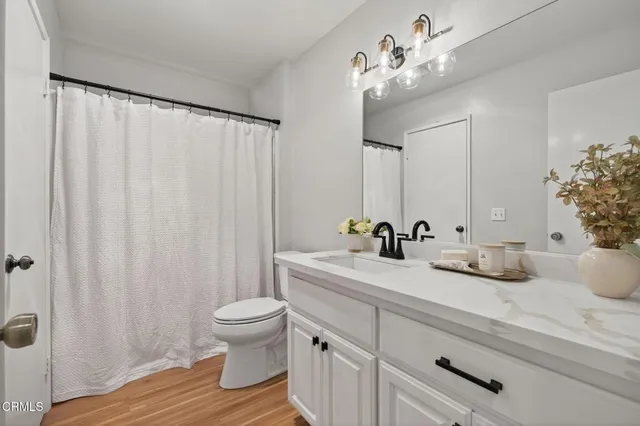 a bathroom with a double vanity sink toilet and shower