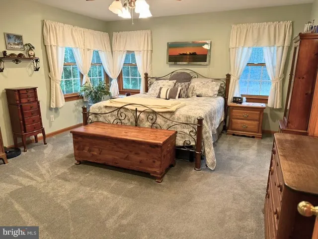 a bedroom with a bed and large windows