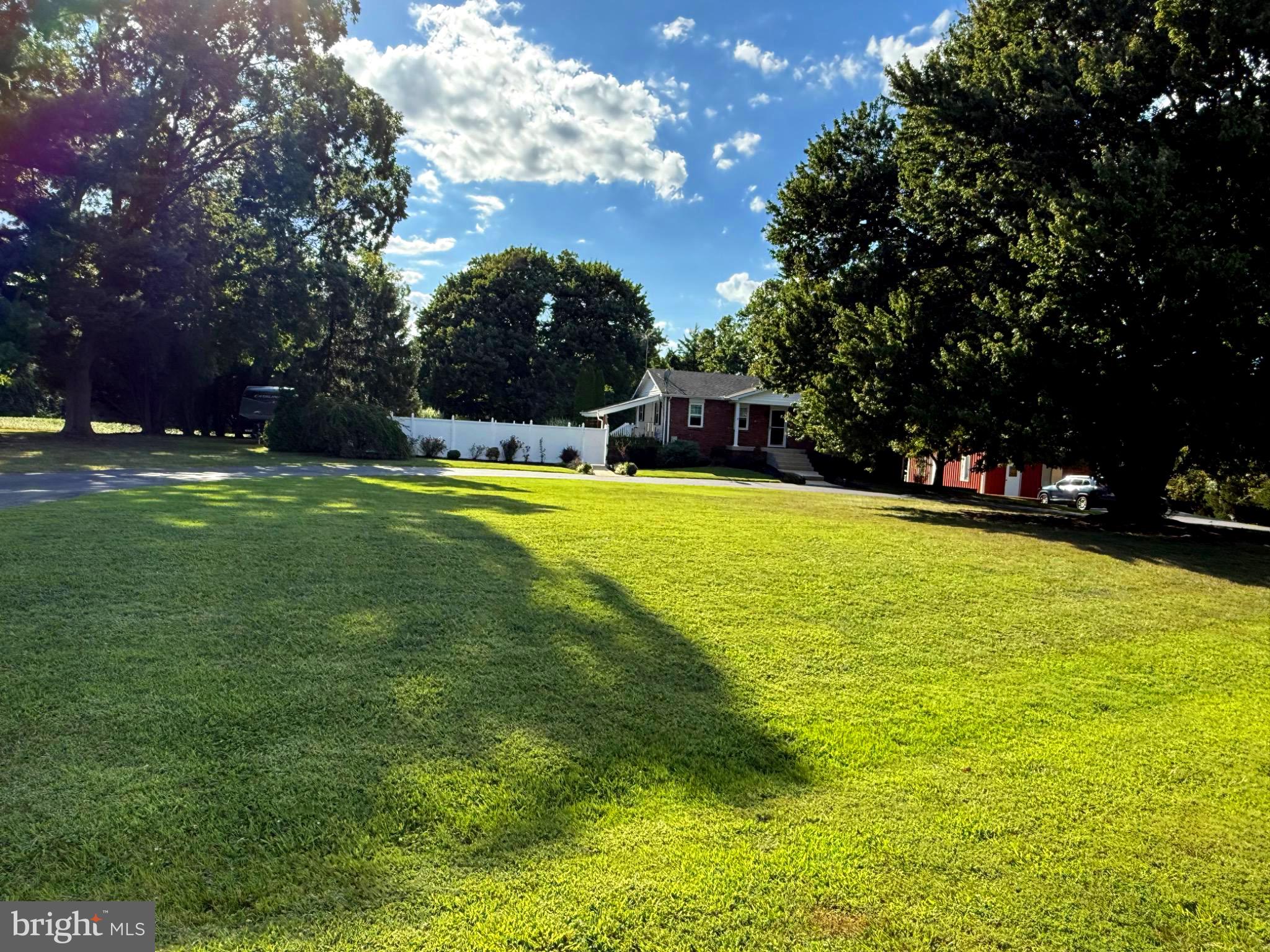31569 Jim Davis Road Galena, MD 21635 - Photo 8 of 42 Spacious lawn under a bright blue sky.