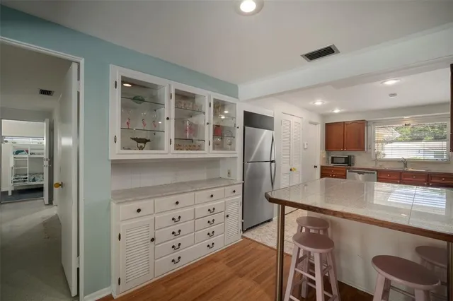a view of a backyard with plants and a large tree