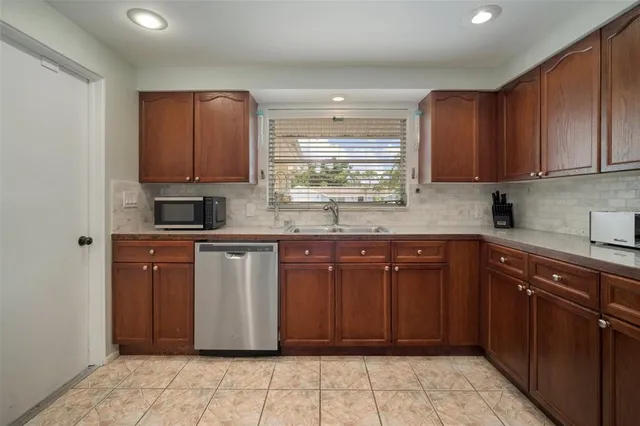 a bedroom with a bed a mirror on dresser and a chandelier