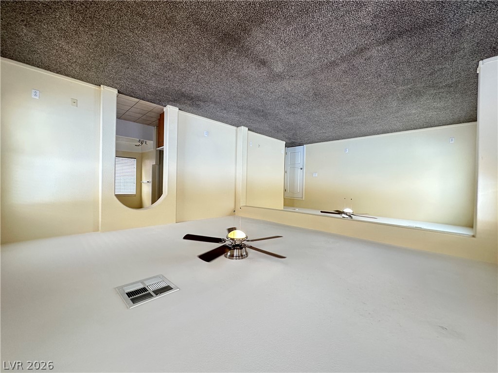 9032 Rutherford Grove Street Las Vegas, NV 89148 - Photo 19 of 24 A spacious, naturally illuminated room featuring soft carpeting and a ceiling fan for comfort.