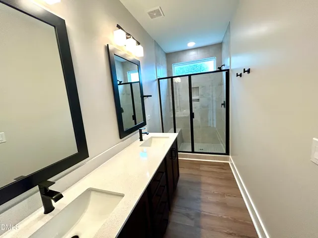 a bathroom with a double vanity sink and mirror
