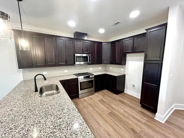 a kitchen with wooden cabinets and stainless steel appliances