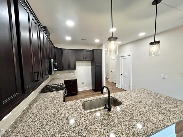 a kitchen with stainless steel appliances granite countertop a refrigerator a oven and a sink