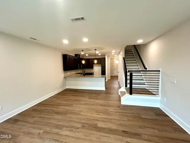 a view of a livingroom with wooden floor and stairs