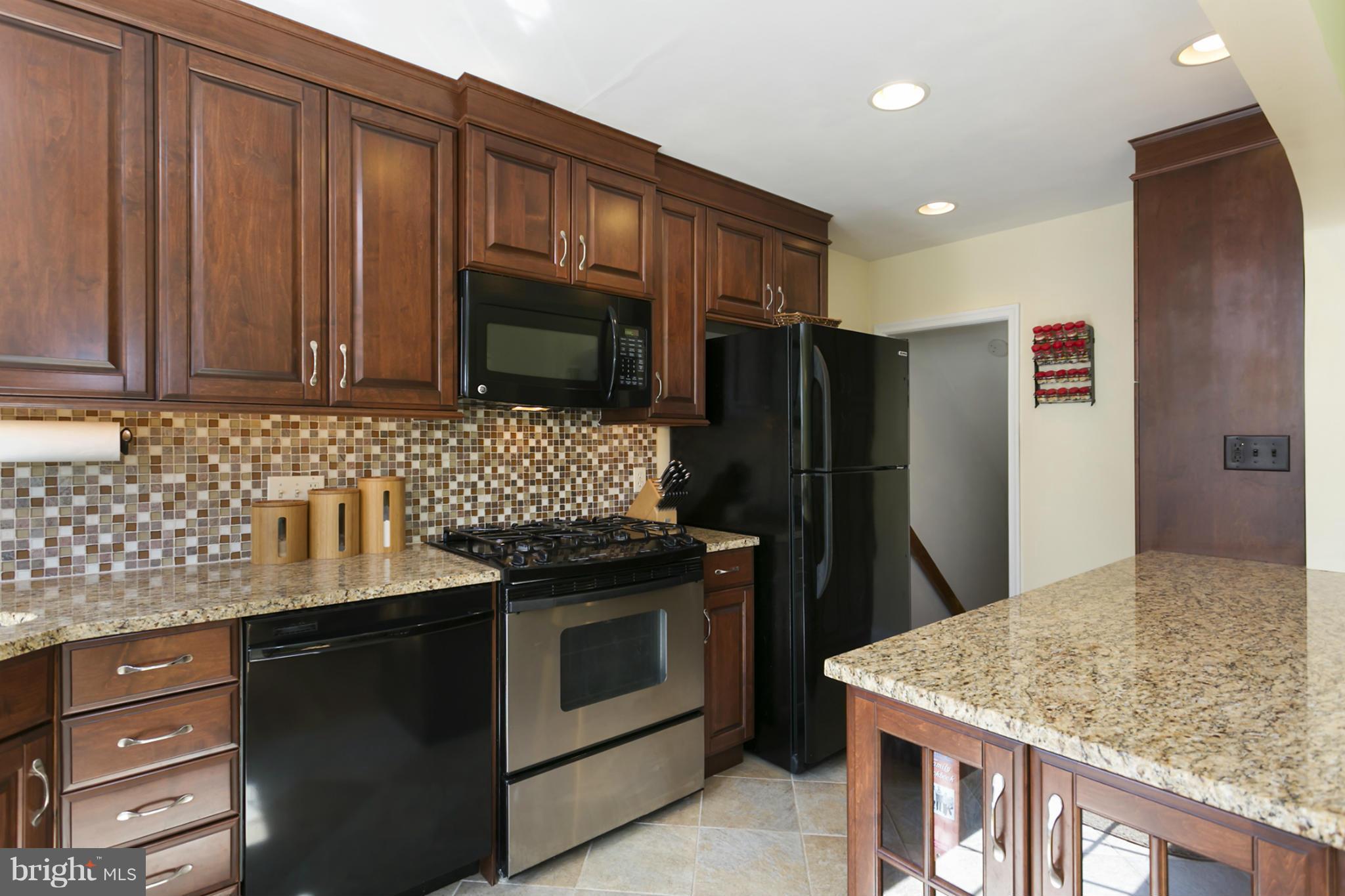 7047 Heathfield Road Baltimore, MD 21212 - Photo 7 of 19 a kitchen with stainless steel appliances granite countertop a stove refrigerator and microwave