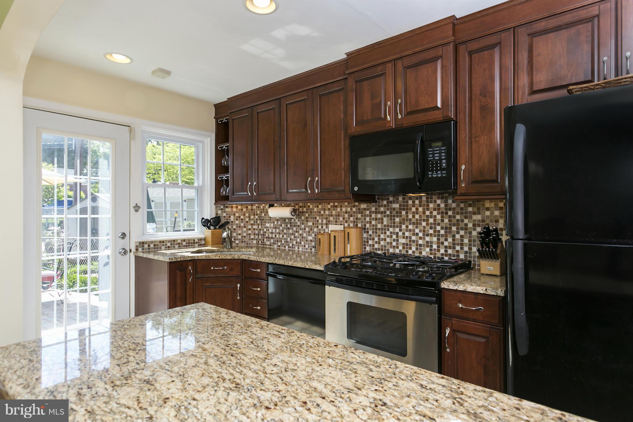7047 Heathfield Road Baltimore, MD 21212 - Photo 8 of 19 a kitchen with granite countertop wooden cabinets and stainless steel appliances