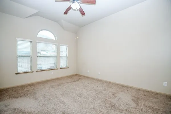 an empty room with windows and fan