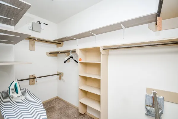 a view of walk in closet with empty racks