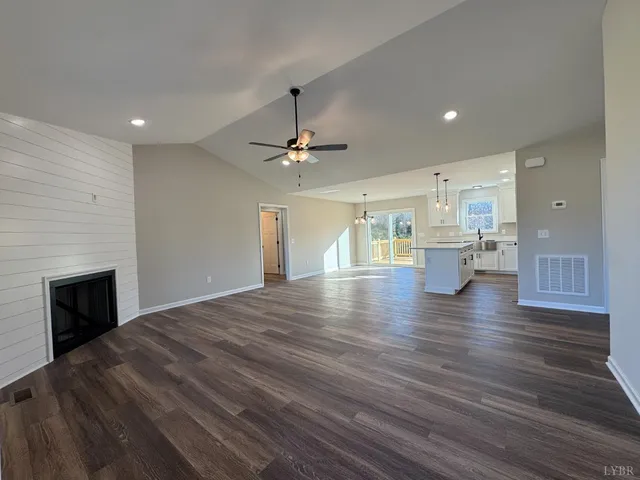 a view of empty room with wooden floor and fireplace