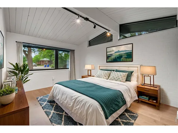 a bedroom with a bed and a large window