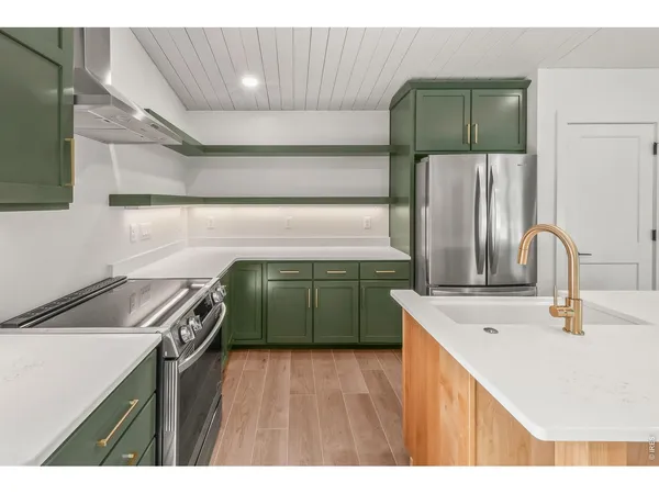 a kitchen with kitchen island sink and wooden floor