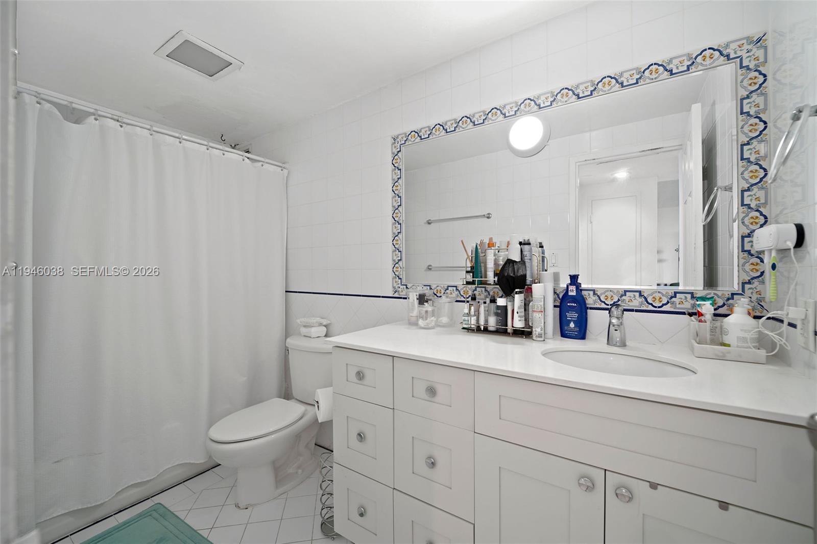 3301 Northeast 5th Avenue, Unit 416 Miami, FL 33137 - Photo 12 of 23 a bathroom with a toilet a sink and a mirror