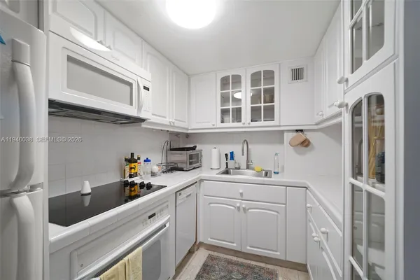 a kitchen with cabinets stainless steel appliances and a sink
