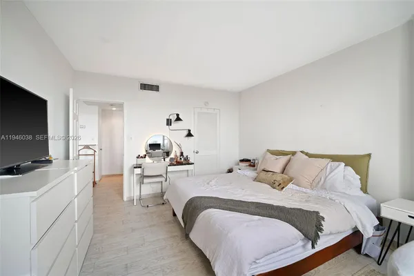 a bedroom with a bed and a flat tv screen on wall