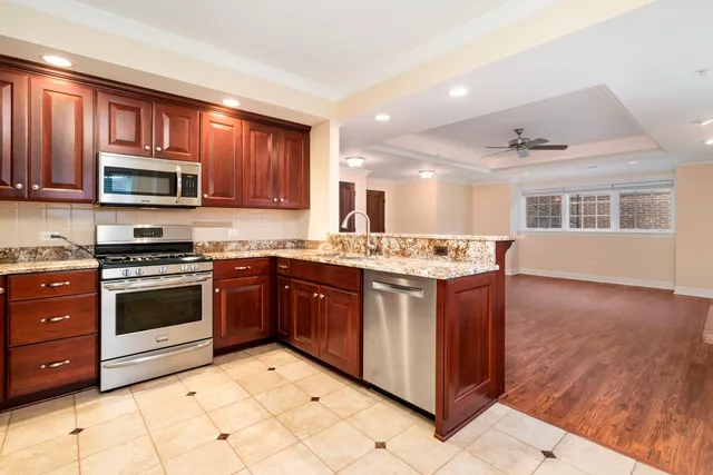 a kitchen with stainless steel appliances granite countertop a stove a sink and a microwave