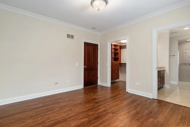 an empty room with wooden floor and closet
