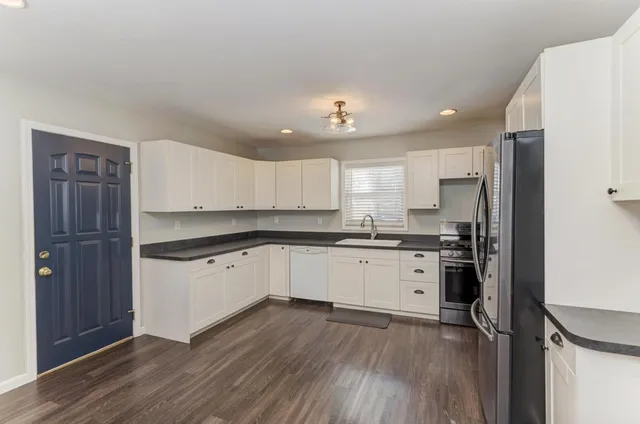 a kitchen with a refrigerator cabinets and wooden floor
