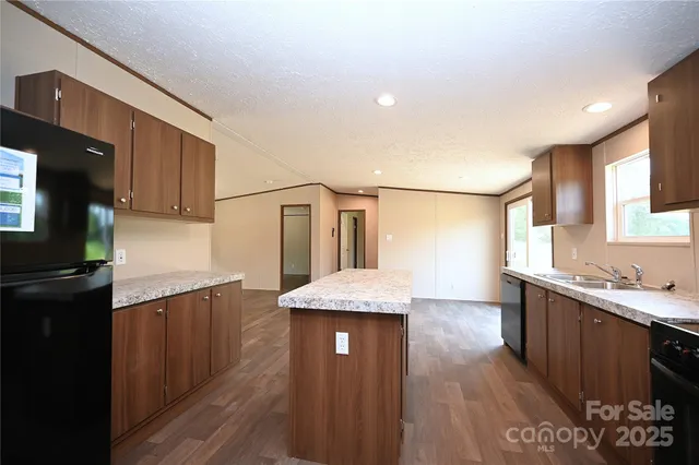 a kitchen with stainless steel appliances granite countertop a sink stove and wooden cabinets