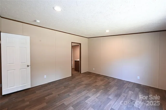 an empty room with wooden floor and closet