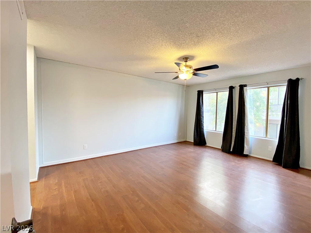 1575 West Warm Springs Road, Unit 1024 Henderson, NV 89014 - Photo 10 of 25 A well-lit living area features rich hardwood floors and an inviting ceiling fan.