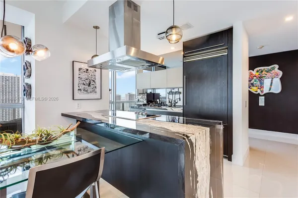 a kitchen with stainless steel appliances granite countertop a sink a refrigerator and a stove