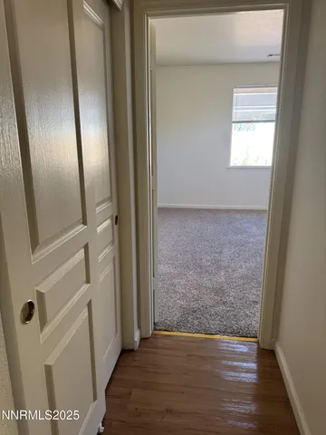 an empty room with wooden floor and mirror