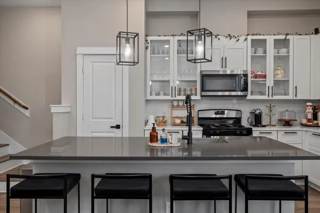 a kitchen with stainless steel appliances a kitchen island a stove a table and chairs in it