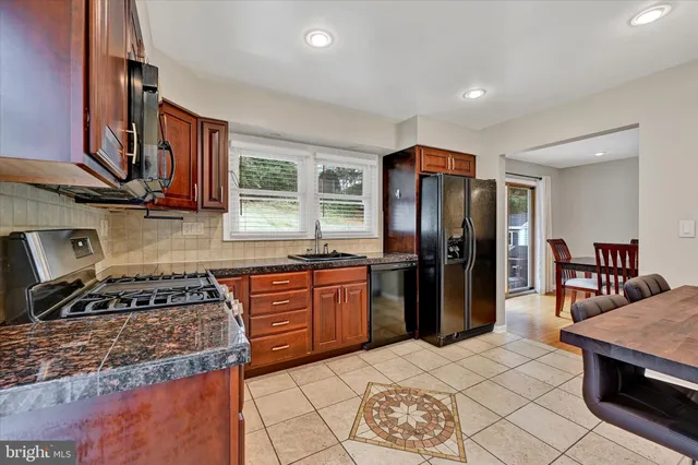 a kitchen with stainless steel appliances granite countertop a stove a sink dishwasher and a refrigerator