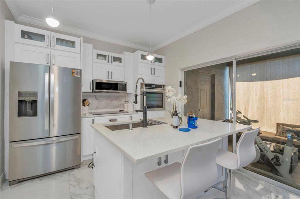6765 Lake Rochester Lane Gibsonton, FL 33534 - Photo 11 of 33 a kitchen with stainless steel appliances a stove refrigerator sink and microwave