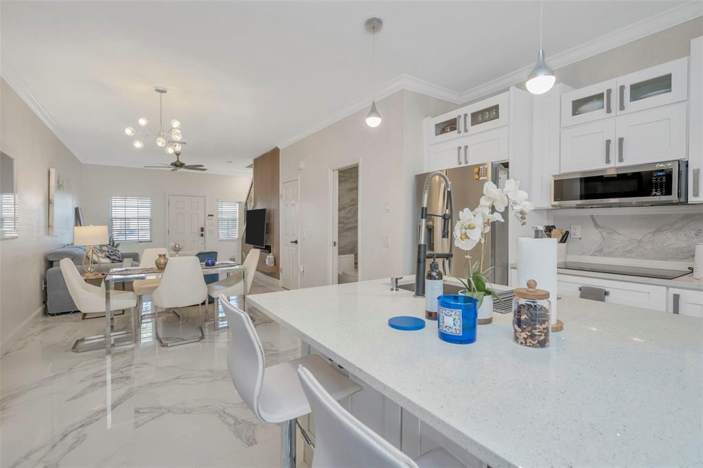 6765 Lake Rochester Lane Gibsonton, FL 33534 - Photo 12 of 33 a kitchen with stainless steel appliances kitchen island granite countertop a table and chairs in it