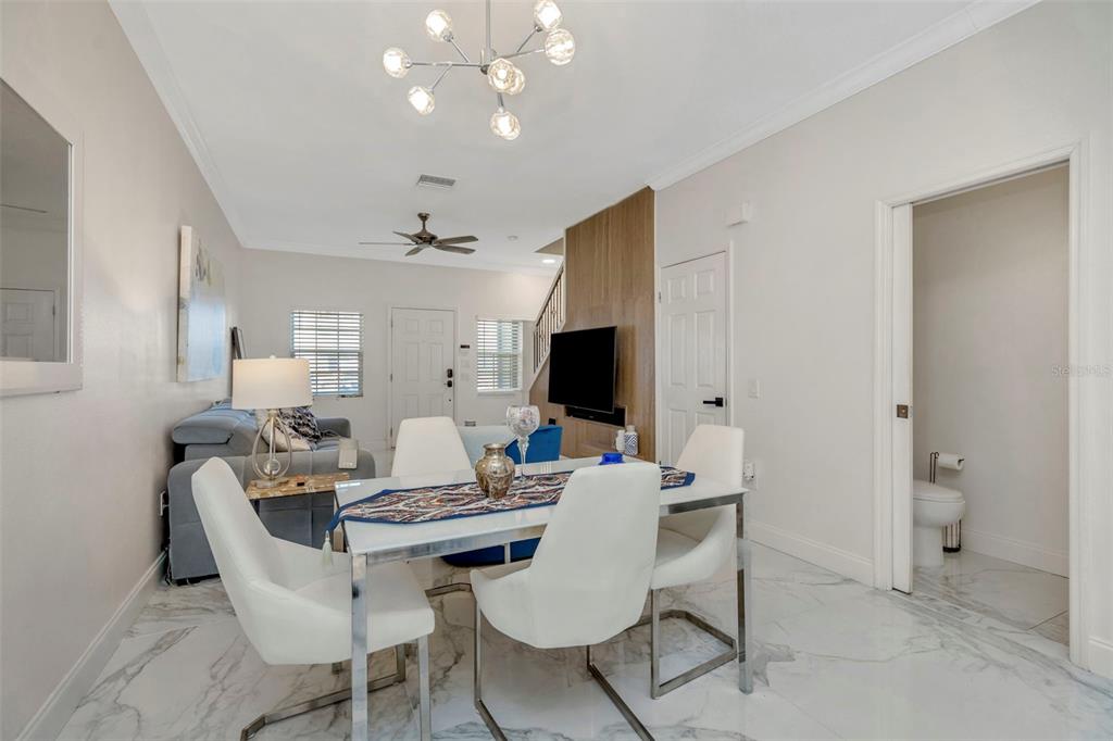 6765 Lake Rochester Lane Gibsonton, FL 33534 - Photo 6 of 33 a living room with furniture a flat screen tv and a dining table