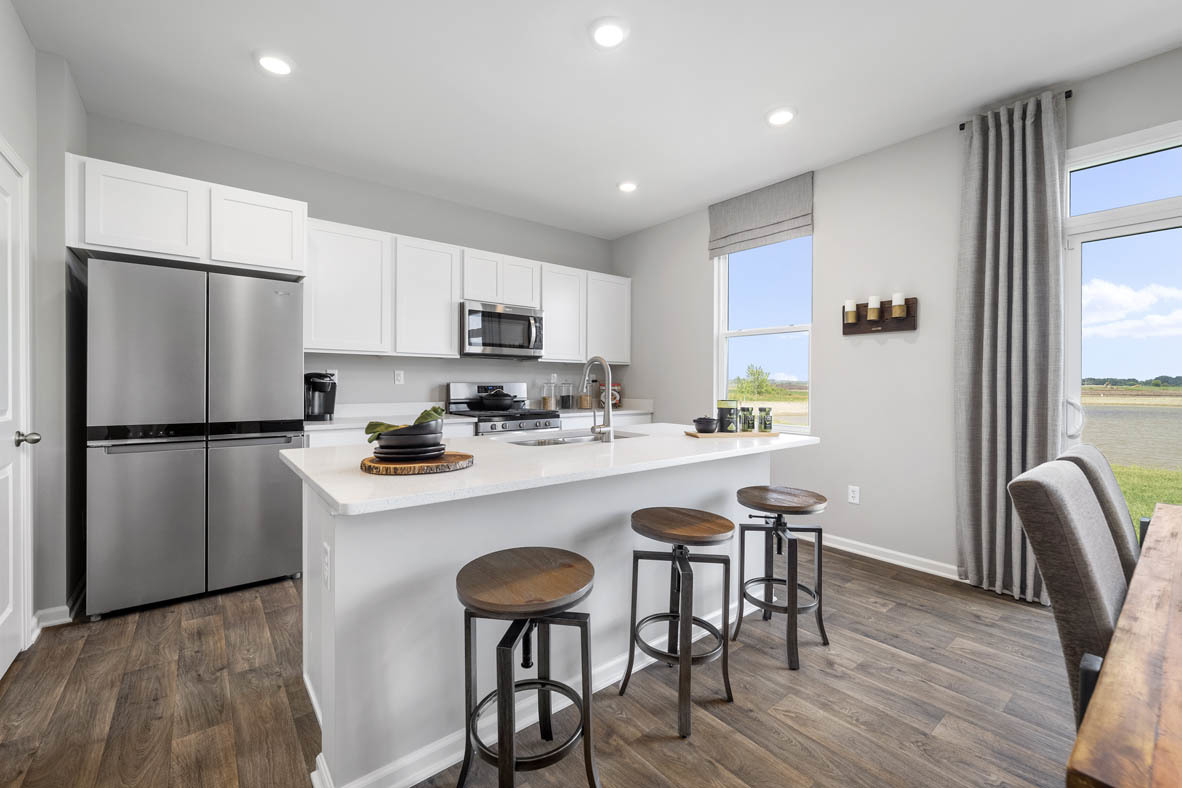 2461 Tahoe Lane Pingree Grove, IL 60140 - Photo 21 of 34 a kitchen with stainless steel appliances a table chairs refrigerator and microwave