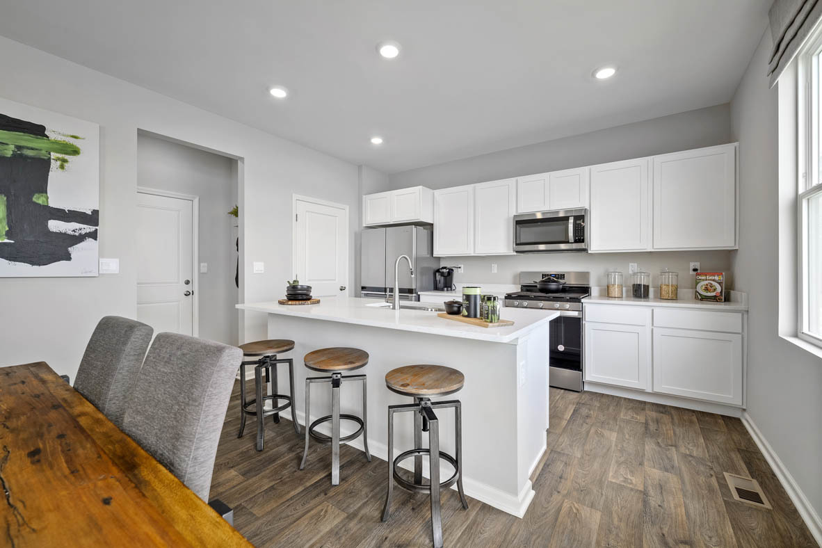 2461 Tahoe Lane Pingree Grove, IL 60140 - Photo 22 of 34 a kitchen with a table chairs a sink dishwasher stove and cabinets with wooden floor