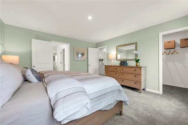 a spacious bedroom with a bed and dresser