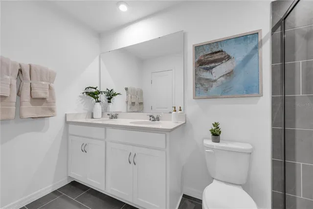 a bathroom with a granite countertop toilet a sink and mirror
