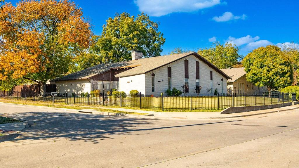 a view of yellow house with a swimming pool